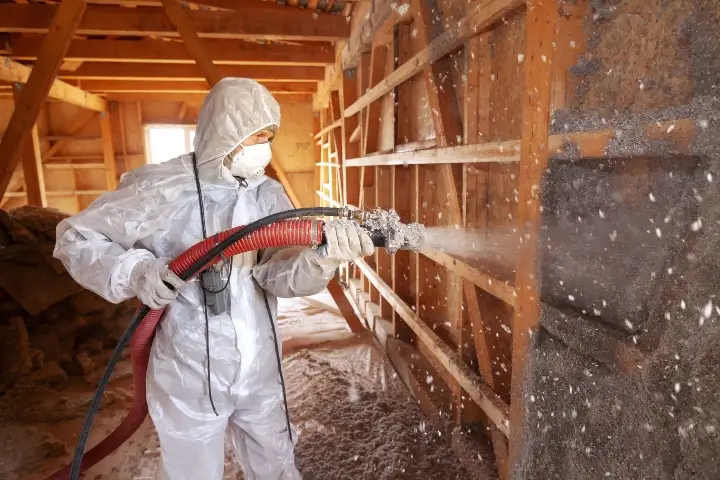 Technician installing insulation in a house attic - TAP installation in Georgia, Tennessee, Alabama, Kentucky, North Carolina and South Carolina