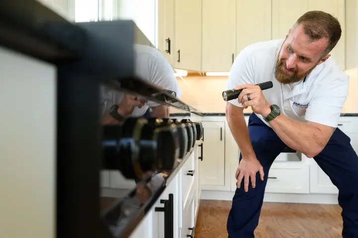 Lookout Pest Control technician inspecting a residential kitchen in Southeastern United States