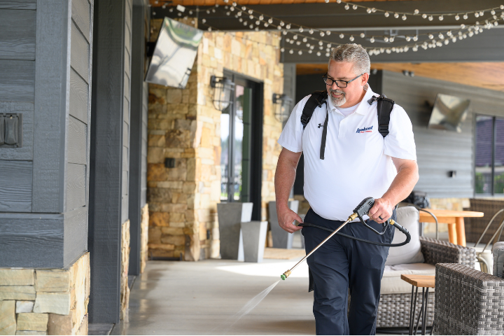 A Lookout Pest Control technician spraying for pests outside a home in Nashville